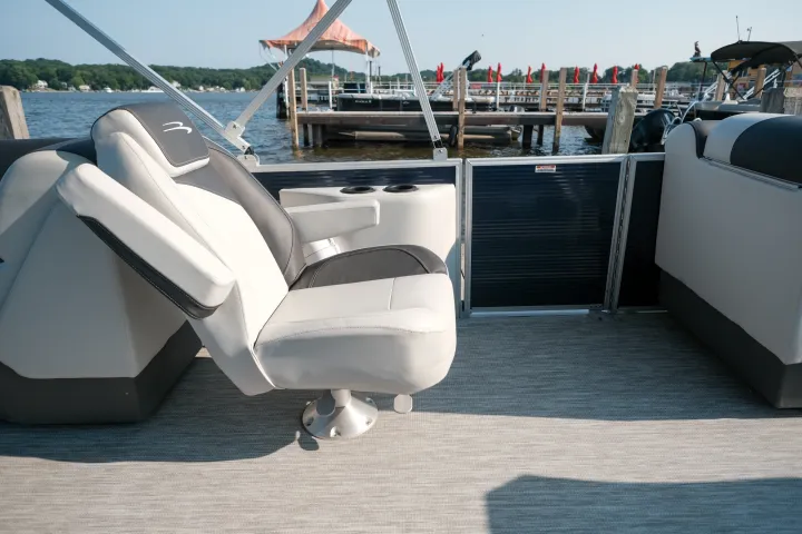 Boat interior with a swivel chair and lake view in the background.